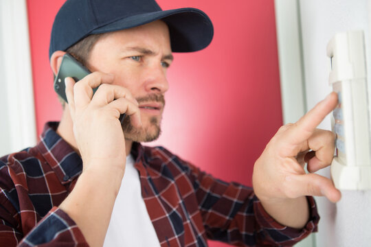 man telephoning for support to enter code in electronic keypad