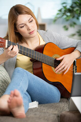 Fototapeta premium pretty girl legs crossed playing some record on guitar
