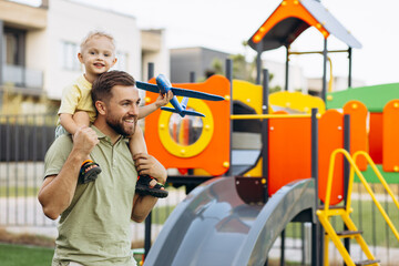 Father with his son playing with toy airplane