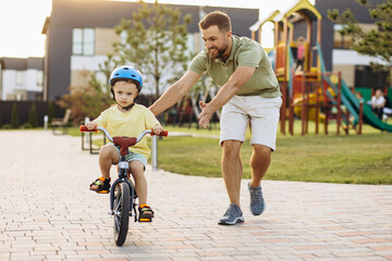 Father teaching his little son to ride a bicycle