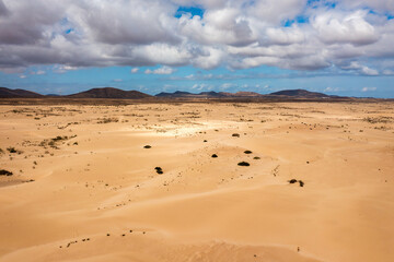 Sand dunes in Las Dunas de Corralejo, Corralejo Natural Park, dramatic cloud formation, Fuerteventura, Canary Islands, Spain. Sand dunes landscape, Corralejo, Fuerteventura, Canary Islands, Spain.