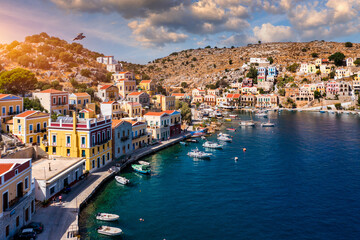 View on Symi (Simi) island harbor port, classical ship yachts, houses on island hills, Aegean Sea bay. Greece islands holidays vacation travel tours from Rhodos island. Symi, Greece,  Dodecanese.