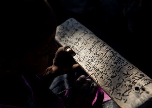 Afar tribe girl writing on a wood board in a coranic school, Afar region, Afambo, Ethiopia