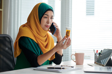 Portrait of mature muslim project manager calling her doctor to discuss effect of new antidepressant