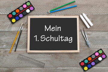 Mein erster Schultag: Tafel mit Buntstiften, Farbkasten und dem Text mein erster Schultag.	