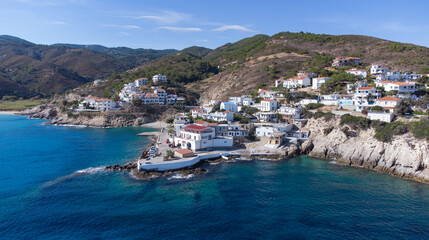 Aerial view of lovely greek fisher town of Armenistis in a quiet summer morning. Port with local beach in transparent clear water at Ikaria, Greece