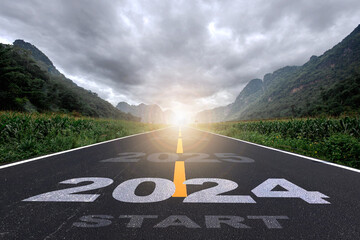 2024, the new year 2024 or the beginning of the concept of the word 2024, written on a road in the middle of a paved road with a sunset mountain backdrop Planning ideas and challenges - obrazy, fototapety, plakaty