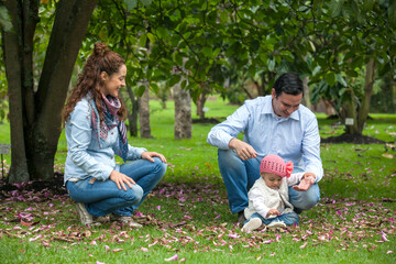 Family of three having fun outdoors in a beautiful sunny day at the park. Happiness concept. Family concept.