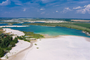 Top view of flooded quarries with white quartz sand. Beautiful artificial lakes with blue water