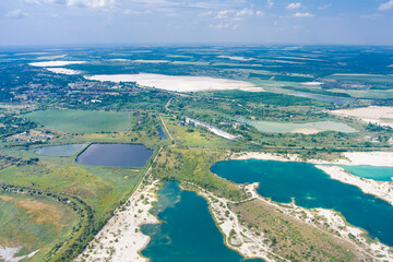 Top view of flooded quarries with white quartz sand. Beautiful artificial lakes with blue water