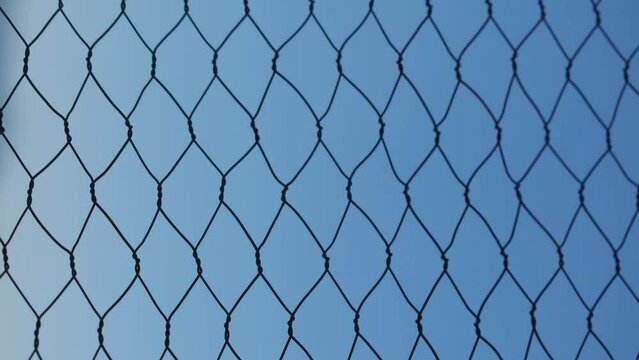Vertical time lapse of cage texture and sunset at background  