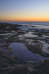 Sunset over tidepools at beach in San Diego California