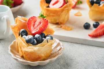 Phyllo or filo pies with fresh berries strawberries and blueberries, cheese filling topped with...