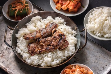 Mouthwatering Kalbi Delight: Top Close-Up of Delicious Grilled Kalbi on Steamed White Rice, Sizzling in a Cast Iron Pan, in 4K Resolution