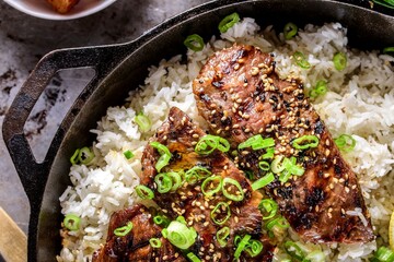 Mouthwatering Kalbi Delight: Top Close-Up of Delicious Grilled Kalbi on Steamed White Rice, Sizzling in a Cast Iron Pan, in 4K Resolution
