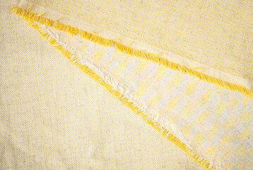 yellow vintage cotton with fringe edges for background, fabric for clothing production close up