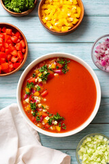 Spanish tomato gazpacho cold soup styled and decorated in white plate on wooden table