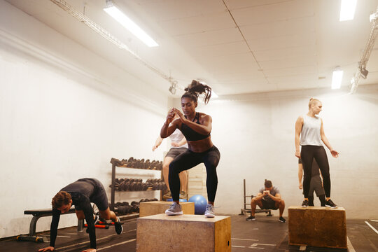 Fit woman doing box jumps during a workout session