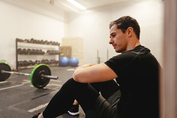 Fit young man taking a break from lifting weights
