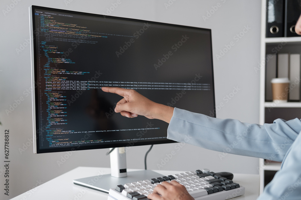 Poster Close up view of programmer pointing to desktop computer with developing programming code, trying to solve the problem.