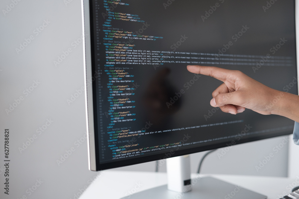 Poster Close up view of programmer pointing to desktop computer with developing programming code, trying to solve the problem.
