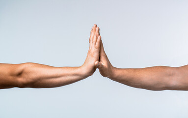 Two hands giving high five to each other, isolated on gray background. Two hands gestures. Giving high five. Two hands, male and man. High five concept for success, teamwork, congratulating