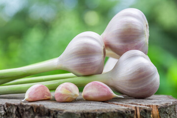 Heads of garlic on a wooden surface outdoors