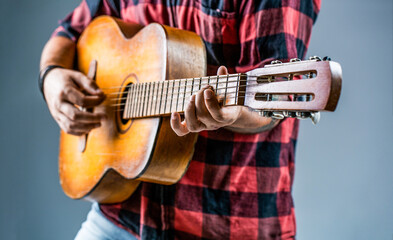 Male musician playing guitar, music instrument. Man's hands playing acoustic guitar, close up....