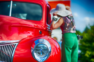 Woman looks at vintage pickup truck.