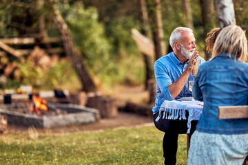 Man talking with family at a table outdoors