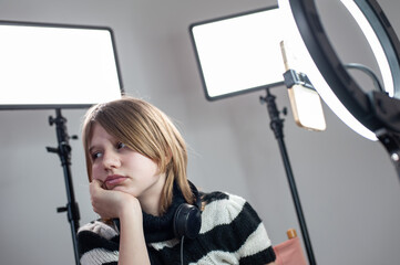 Young woman making photo or video content for social media with smartphone and light of ring lamp....