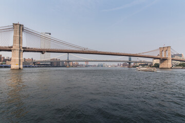 Brooklyn Bridge and Manhattan bridge with a ferry passing by.