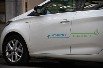 Electric vehicle (EV) connected on plug for charging, Clean mobility, 100% electric, reduction of CO2 and green energy, eco and environmental friendly, renewable energy
