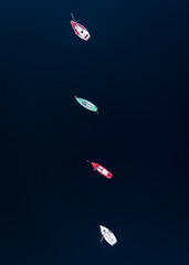 Topdown shot of 4 boats on a lake. 