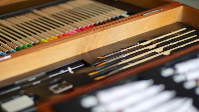 A professional drawing and painting set in a wooden case rotates in front of the camera.