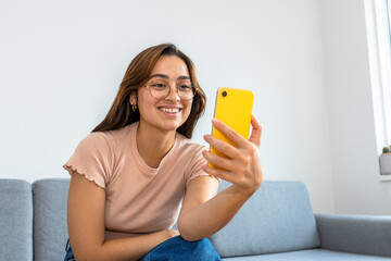 woman sitting on the sofa using the phone