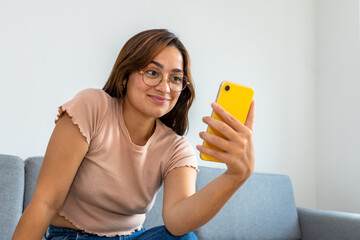 woman sitting on the sofa using the phone