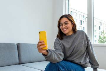 woman sitting on the sofa using the phone
