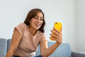 woman sitting on the sofa using the phone