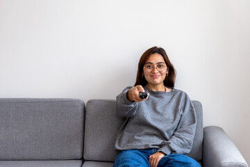 black-haired woman in gray sweater watching tv