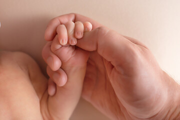 newborn baby holds mom's finger. hand of a newborn baby