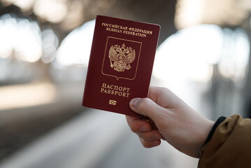 Russian passport on a black travel suitcase, selective focus. Emigration of Russians from the...
