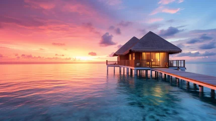 Fotobehang Bora Bora, Frans Polynesië Maldives sunset on the beach at a tropical resort with water cabanas