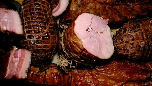 Close up while moving camera above smoked ham and other meat cuts like rib and bacon. Home build smoker was using to self smoke meat cuts.