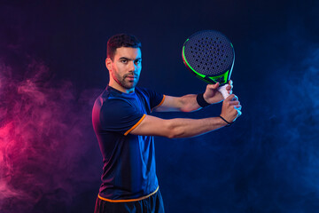 Padel tennis player. Man athlete with paddle tenis racket on black background. Sport concept....