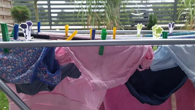 Wet colorful underwear clothes hanging and drying on the dryer