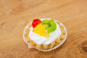 Cake with cream and pieces of fruit. Muffin with cream and marmalade.