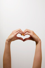 Hand with yellow manicure showing love heart sign