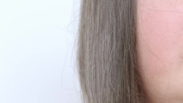 close up middle-aged female face, brown-haired woman 50-55 years old combs with brush long brown with gray hair, age-related changes, self-appreciation, Hair care and grooming for mature women