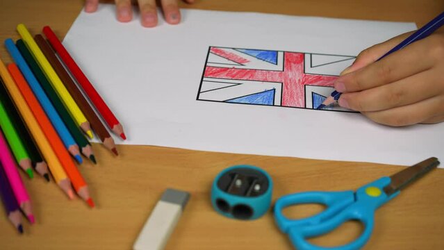 Sheet of paper with the outlines of the English flag. The child paints the flag of Great Britain with colored pencils